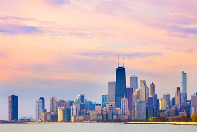 Skyscrapers in city against cloudy sky