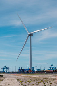 Wind turbines on land against sky