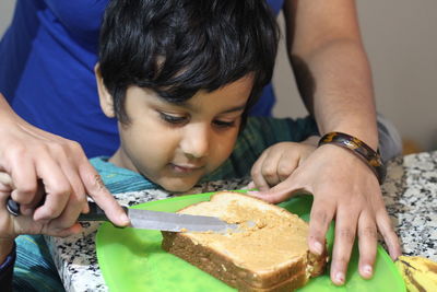 Cropped image of mother and son preparing food