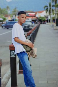 Portrait of young man standing in city