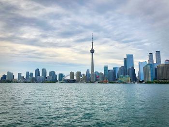 Modern buildings in city against cloudy sky