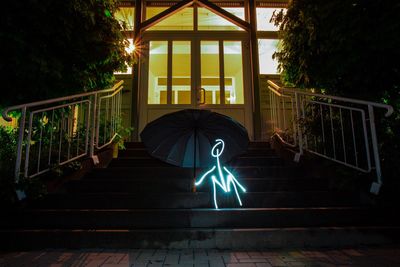 Light painting by umbrella against house at night