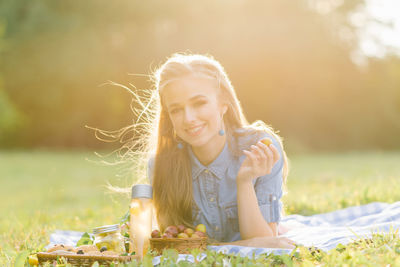 A pretty young woman is resting, lying on a blanket. summer picnic in the park