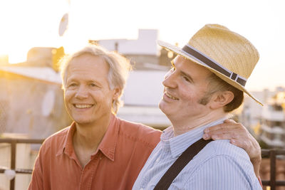 Friends standing on terrace during sunset