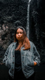 Portrait of beautiful woman standing against tree