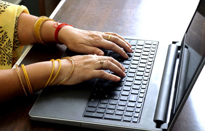 Cropped hands using laptop