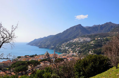 Scenic view of town by sea against sky