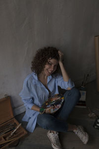 Young woman sitting on sofa at home