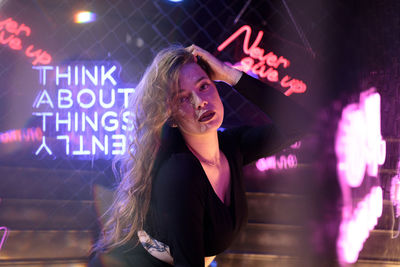 Portrait of woman standing against illuminated light