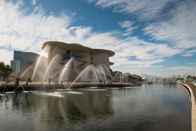 Fountain in lake against cloudy sky