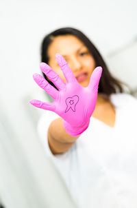 Close-up portrait of woman holding pink flower