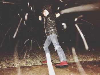 Boy playing with umbrella at night