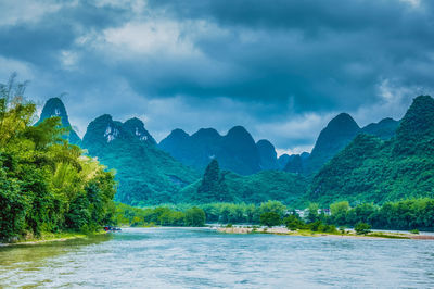 Scenic view of forest against dramatic sky