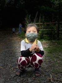 Portrait of cute girl sitting outdoors