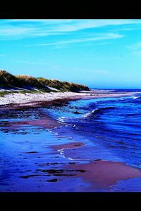 Scenic view of sea against blue sky