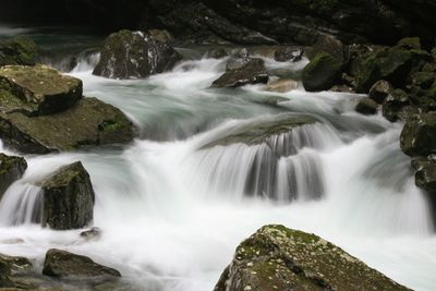 Scenic view of water streaming past rocks