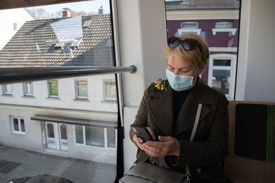 Woman looking out the window of wuppertaler schwebebahn, wuppertal suspension