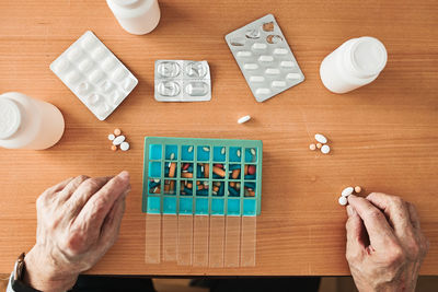 Senior man organizing his medication into pill dispenser. senior man taking pills from box