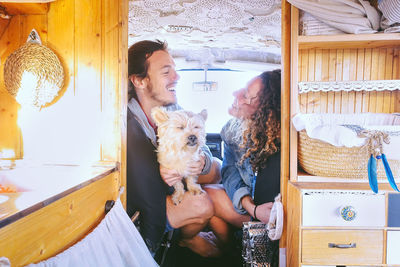 Man and woman with dog sitting in caravan