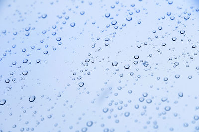 Raindrops on glass in cold colors. soft focus cold background rainy day