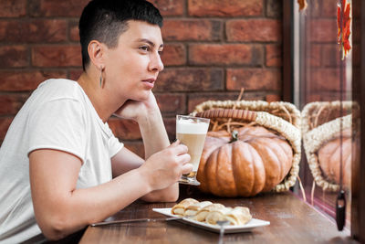 Thoughtful woman having breakfast at table
