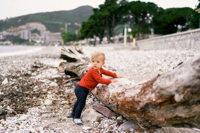 Full length of boy looking away on rock