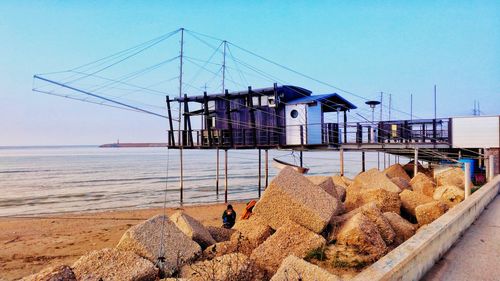 Traditional windmill on beach against sky