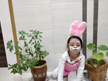 Portrait of cute girl in potted plant