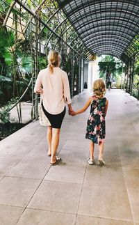 Rear view of women walking on footpath
