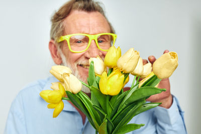 Portrait of senior man holding flower bouquet