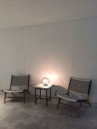 Empty chairs and table against wall at home