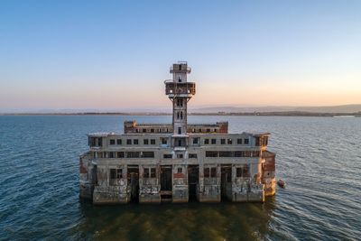 Built structure by sea against clear sky