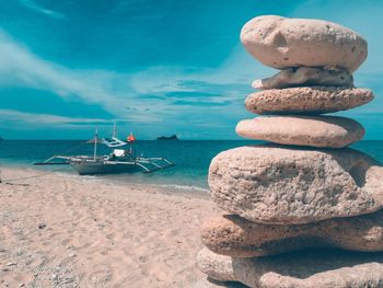 Stack of pebbles on beach against sky