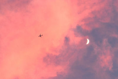 Low angle view of silhouette airplane against sky during sunset