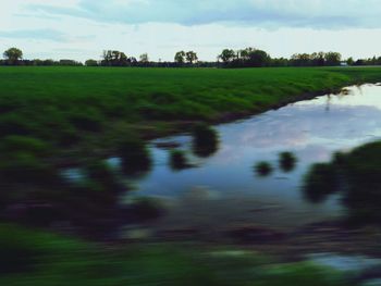 Scenic view of field against cloudy sky