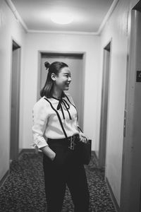 Woman looking away while standing in building