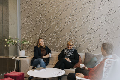 Smiling people talking in office lobby