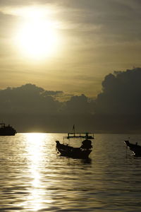 Boat sailing in sea at sunset