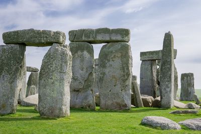 Stonehenge on field against sky