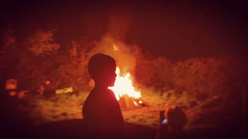 Rear view of silhouette man against bonfire