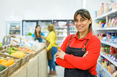 Smiling owner with arms crossed at store