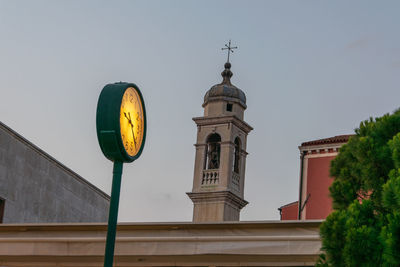 Low angle view of clock tower amidst buildings against sky