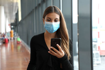 Woman wearing mask looking away in airport
