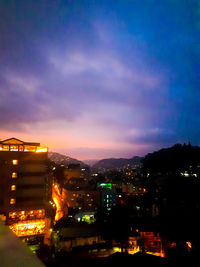 High angle view of illuminated buildings against sky at night