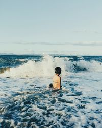 Man in sea against sky