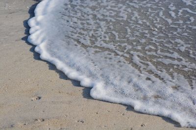 High angle view of footprints on sand at beach