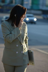 Rear view of woman standing on road