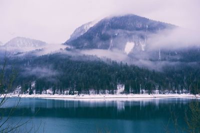 Scenic view of lake by mountains against sky