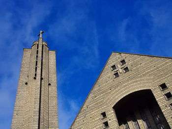 Low angle view of church against blue sky on sunny day