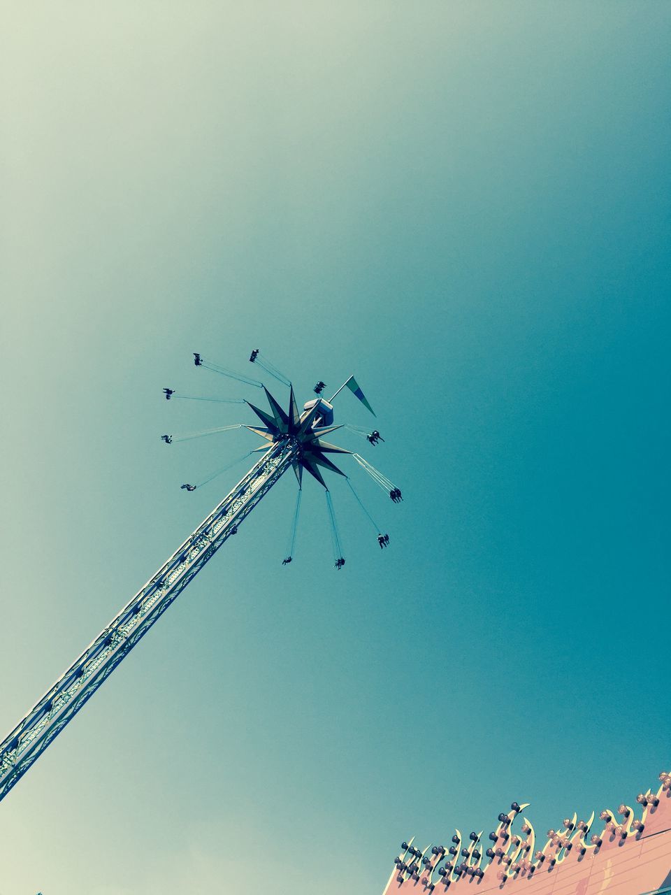 low angle view, clear sky, amusement park, animal themes, copy space, built structure, animals in the wild, architecture, arts culture and entertainment, amusement park ride, blue, outdoors, sky, day, no people, building exterior, ferris wheel, wildlife, flying, bird